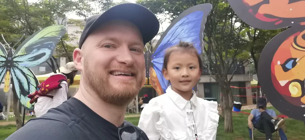 Isaac and a child visiting an exotic butterfly park and tropical gardens.