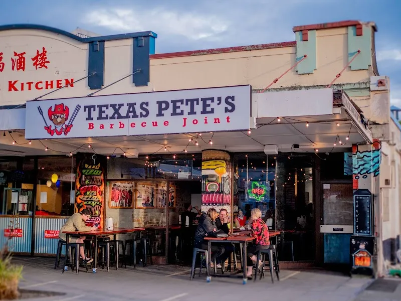 Texas Pete's Barbecue Joint storefront with street dining tables and neon signage.